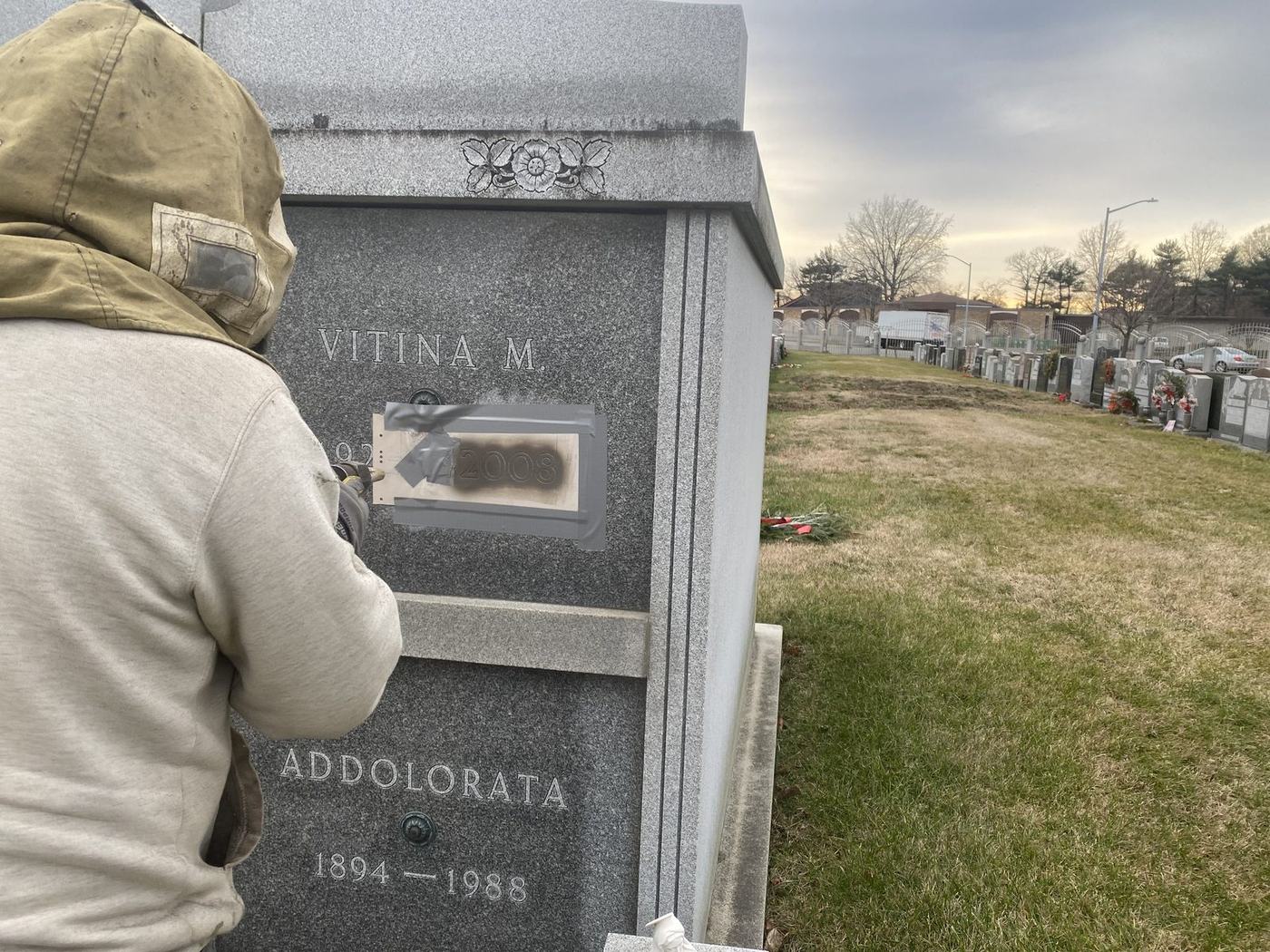Lawn crypt inscription in progress - Monument Inscriptions Engraver adding an inscription to a granite lawn crypt at a cemetery